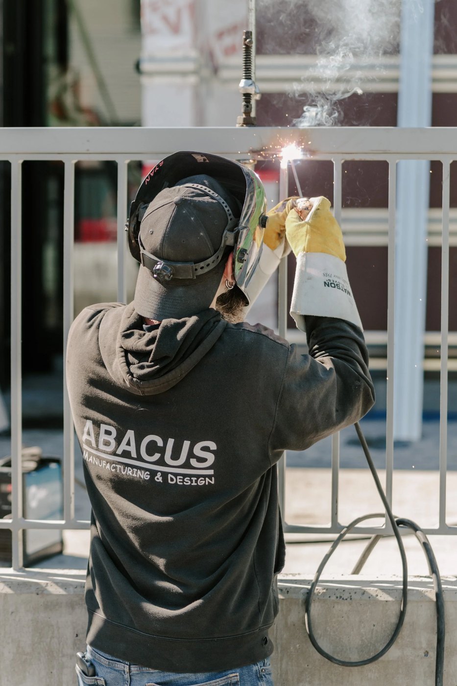 Welder in protective equipment working on a metal railing