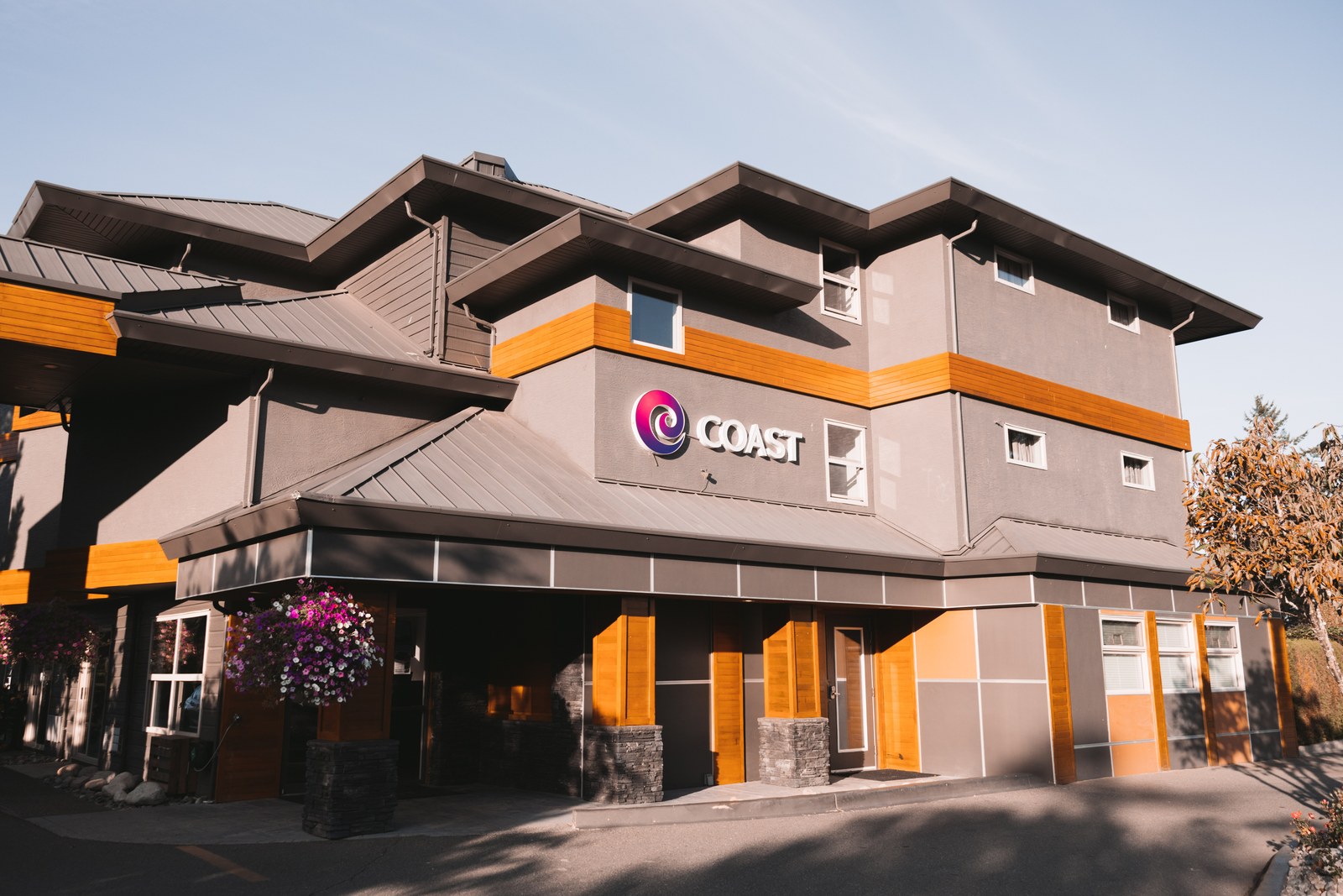 The Coast Parksville Hotel exterior in afternoon light with its sign and orange facade