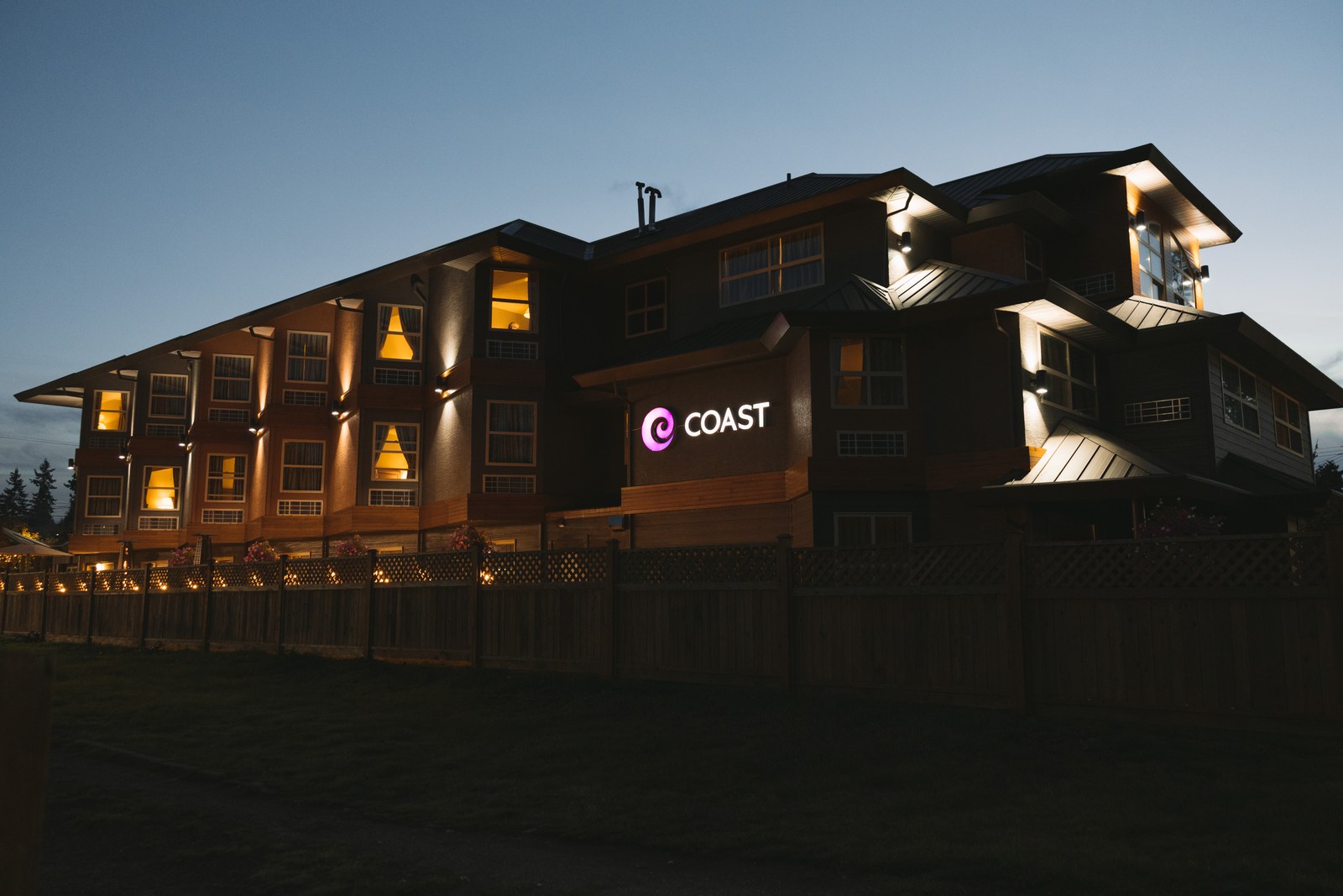 Coast Parksville Hotel at dusk with its illuminated sign and warm windows