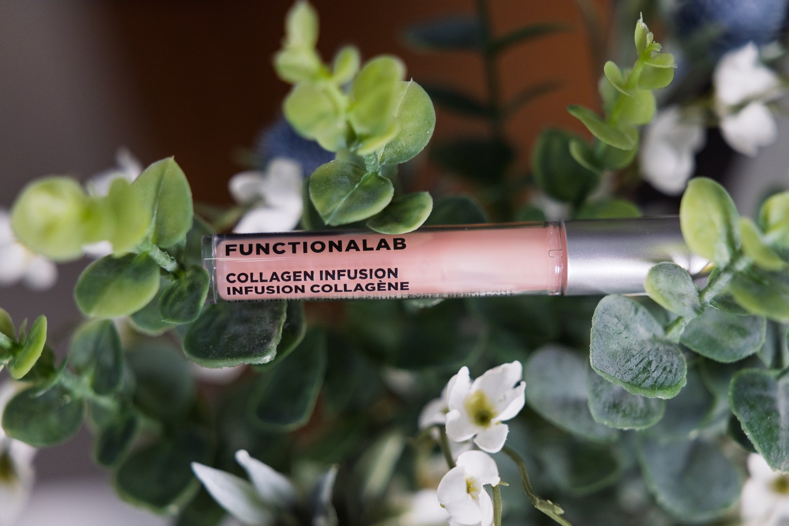 Functionalab collagen infusion tube styled among green leaves and small white flowers